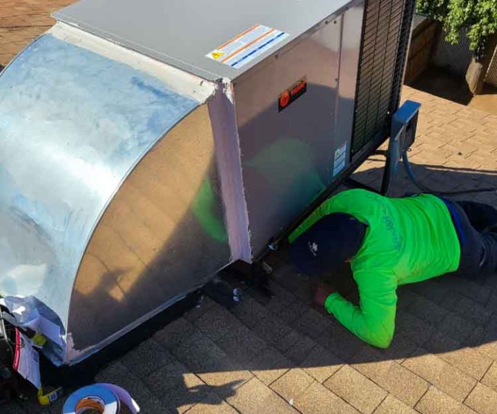 HVAC Repair on rooftop done by a skilled technician wearing neon green top